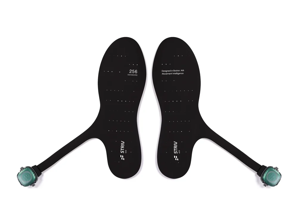 A pair of STRIV research insoles, each with a sensor pod on a short tail
